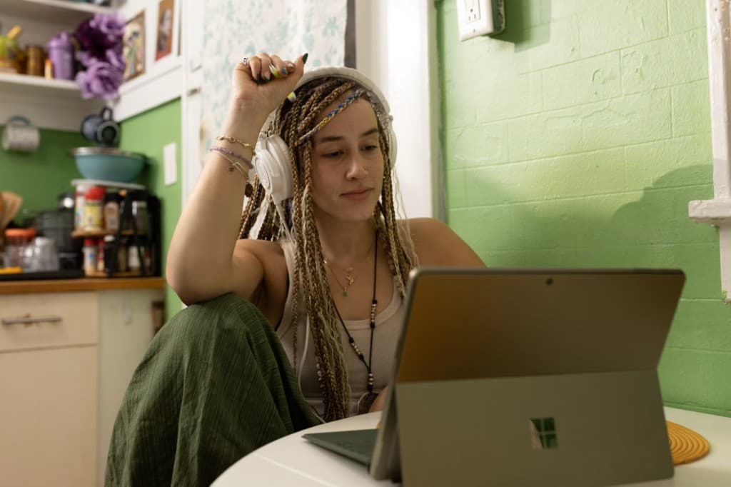 Student studying on a laptop at a kitchen table