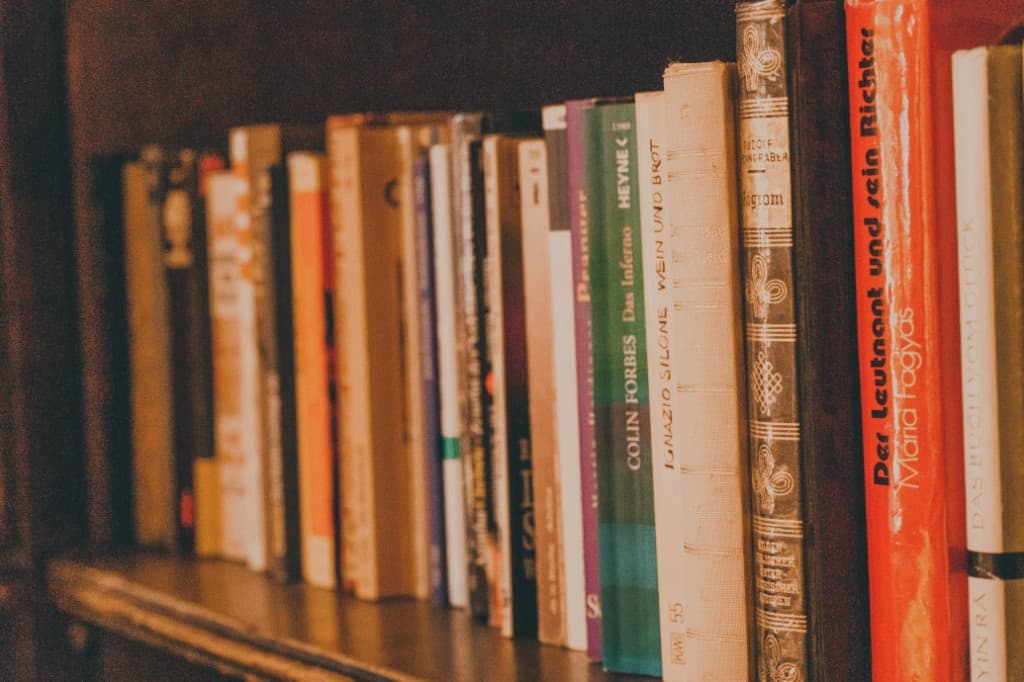 Row of books on a wooden shelf