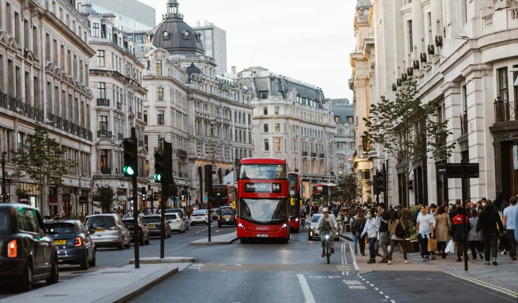 Red London buses on a busy West End street