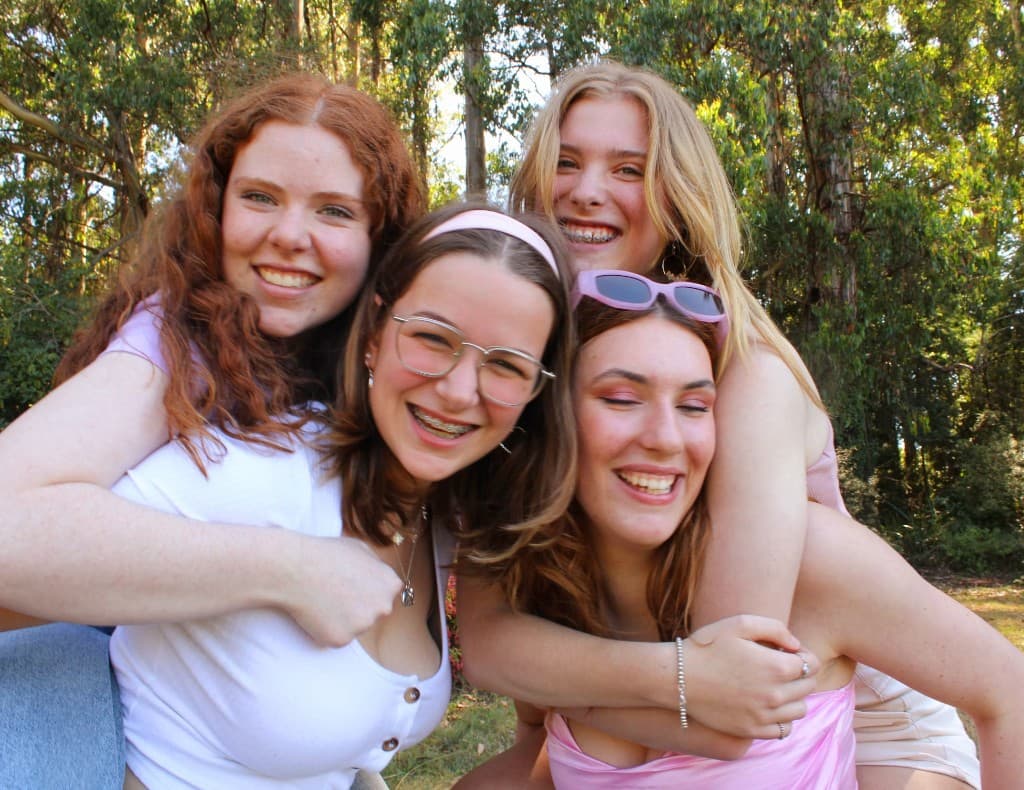 Group of young women smiling and hugging outdoors